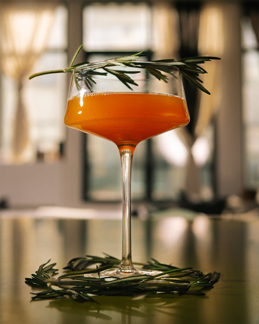 Gold Standard 24K Magic zero-proof cocktail with garnish on table.