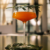 Gold Standard 24K Magic zero-proof cocktail with garnish on table.