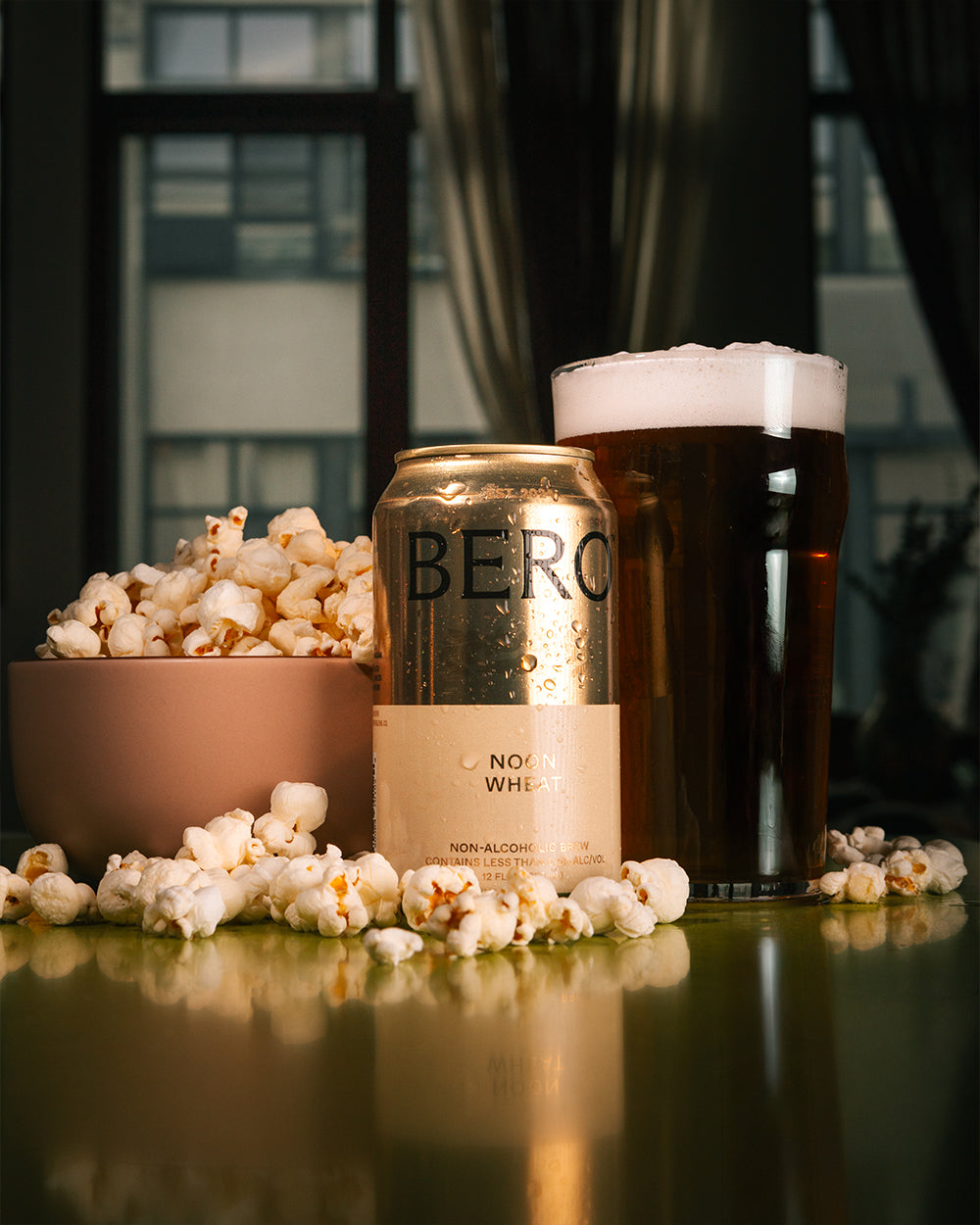 Bero Noon Wheat non-alcoholic beer beside bowl of popcorn.