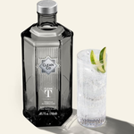 Clean Co tequila bottle with a cocktail garnished with lime on a light background