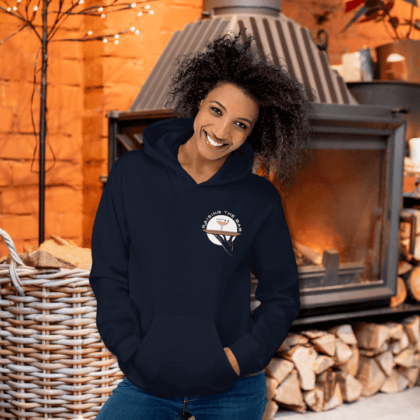 A woman is standing in front of a fireplace wearing a navy sweatshirt, enjoying a relaxing moment after happy hour.