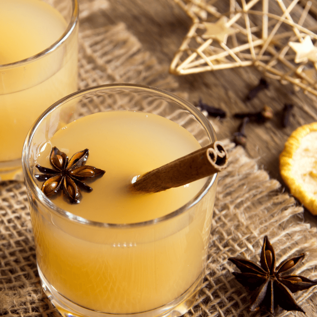 Two glasses of orange juice with cinnamon sticks and star anise, perfect for the sober curious or those exploring zero-proof options.