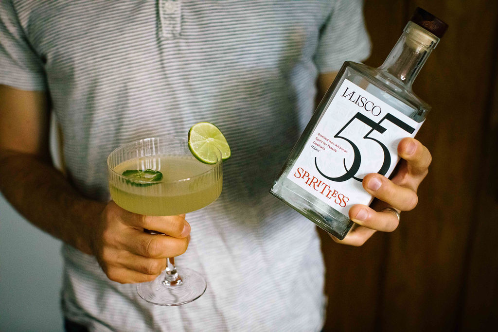 A man showcasing a subscription box filled with delightful cocktails, perfect for happy hour.