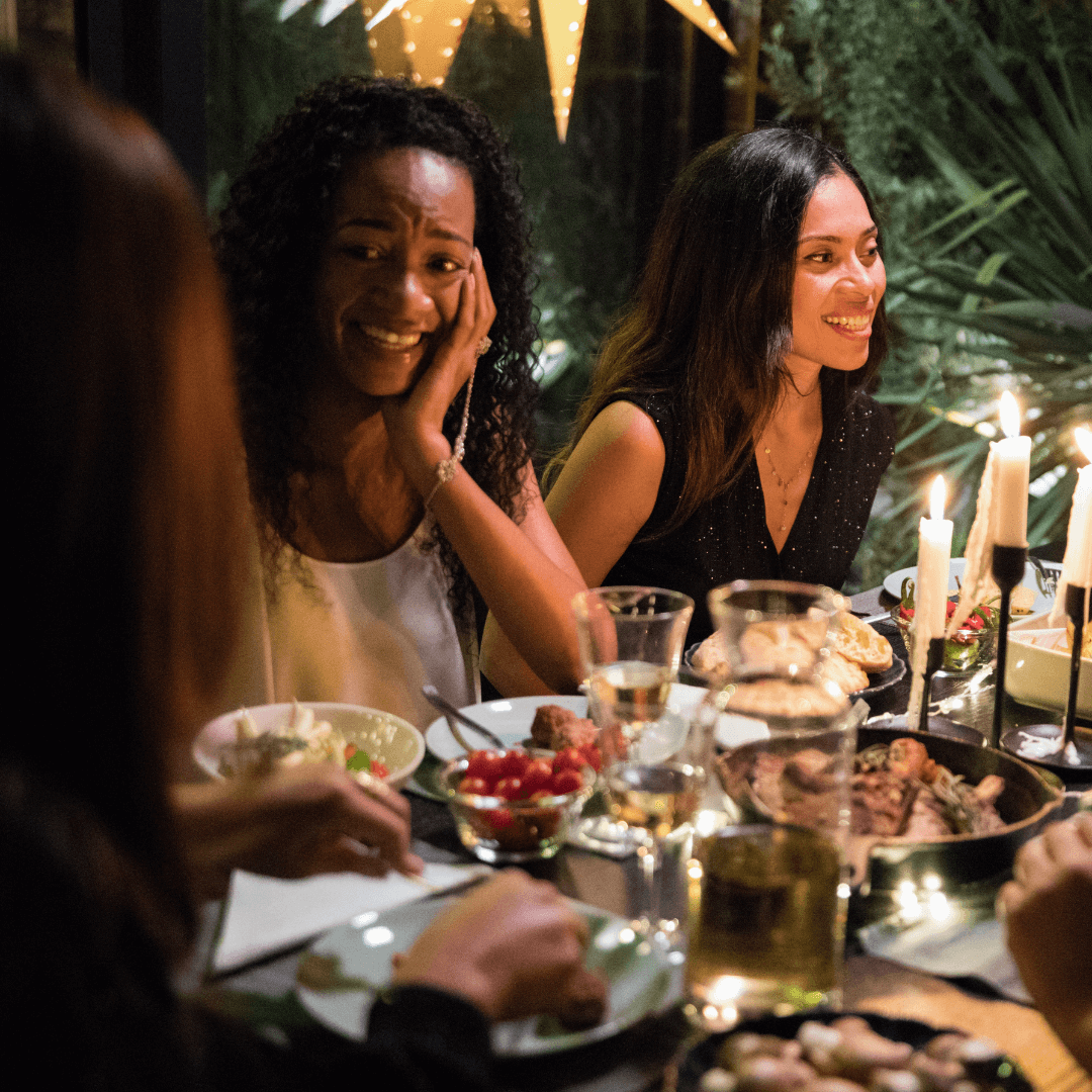 A group of women enjoying a happy hour at a dinner table with zero-proof drinks.