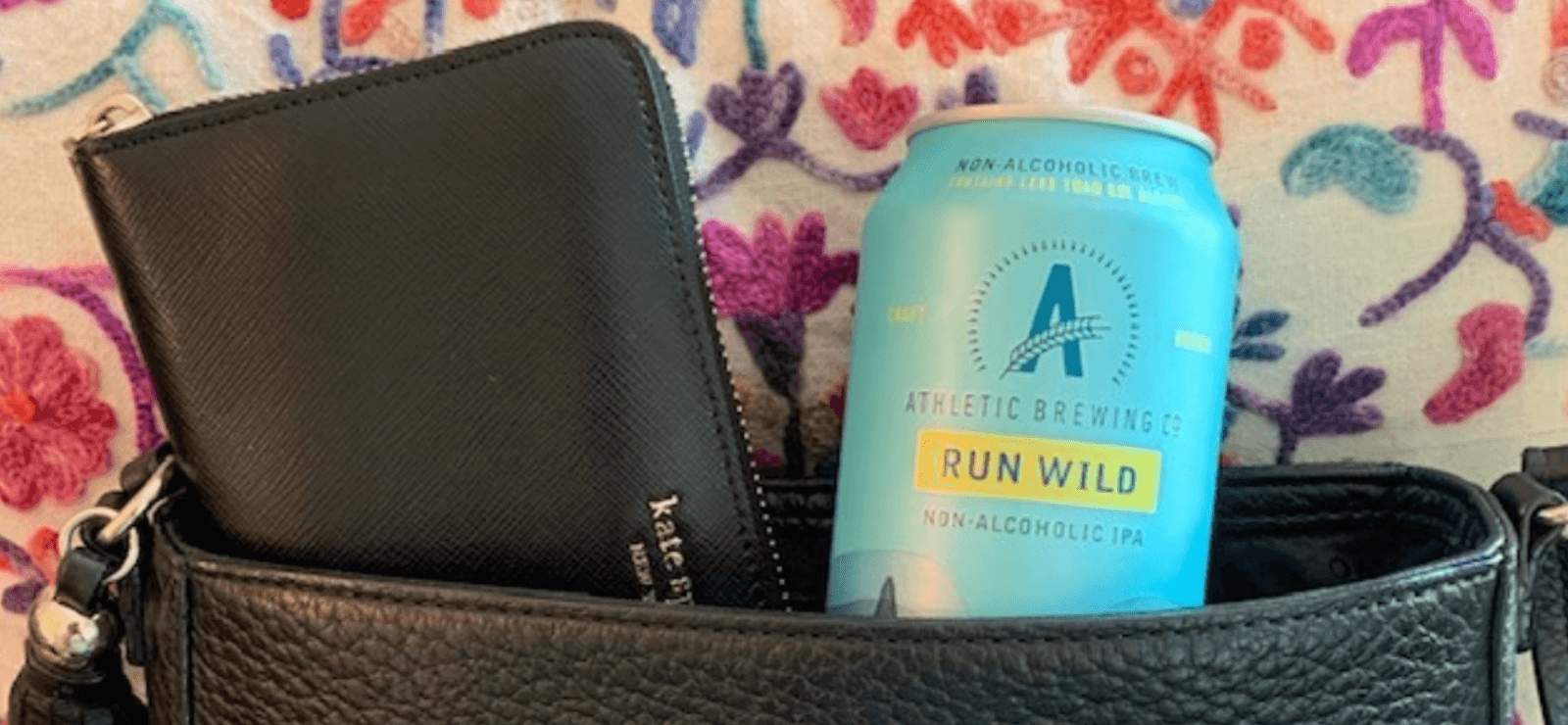 A black purse with a subscription box of alcohol-free, zero-proof drinks.