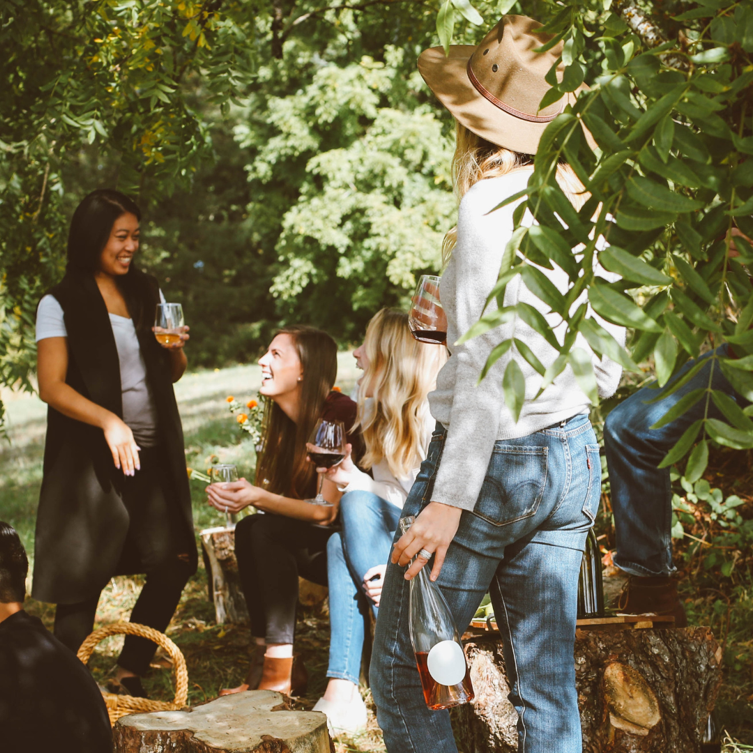 A group of sober curious individuals sitting around a tree, enjoying an alcohol-free gathering.