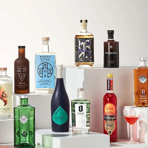 A collection of gin bottles on a white shelf, perfect for the cocktail enthusiast or those embracing the sober curious lifestyle.